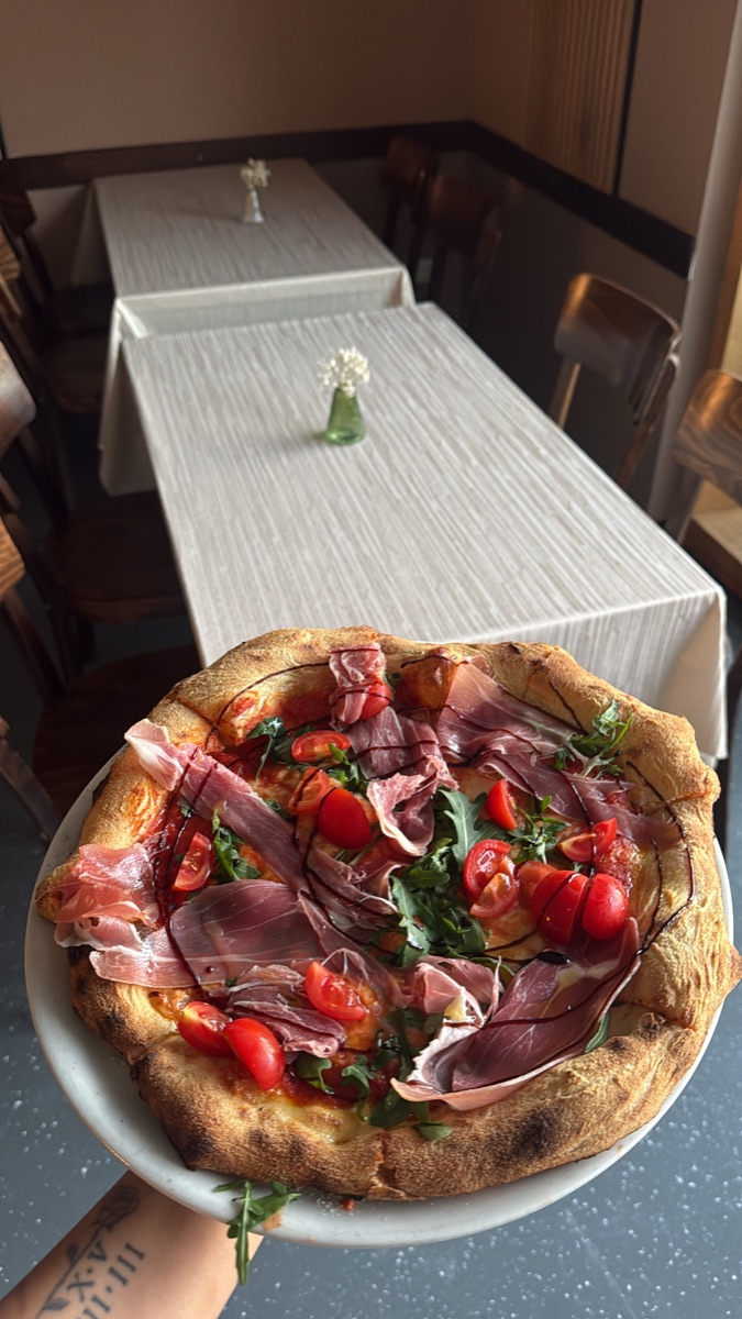 Pizza mit Prosciutto, Rucola und frischen Tomaten