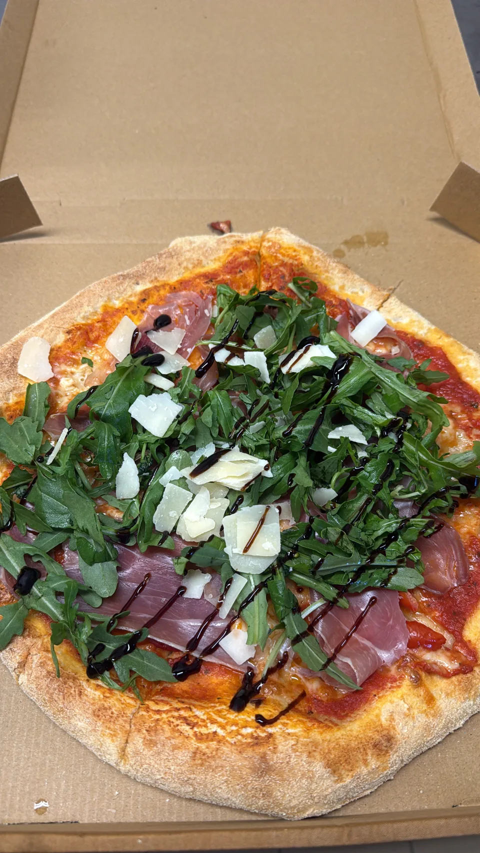 Pizza mit Prosciutto, Rucola und Parmesan bei La Vittoria